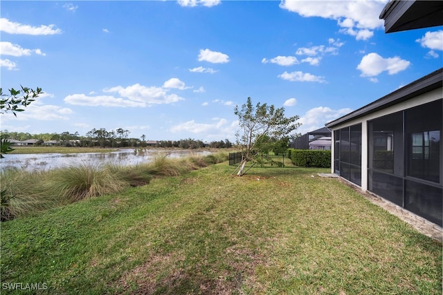 view of yard featuring a water view and a sunroom