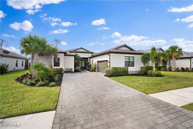 single story home featuring a garage and a front lawn