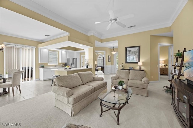 carpeted living room with ceiling fan and ornamental molding