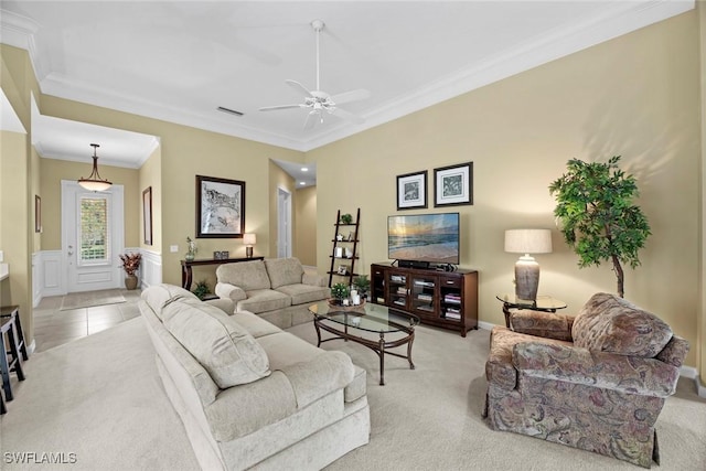 living room with ceiling fan, crown molding, and light carpet