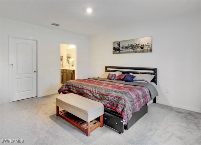 bedroom with ensuite bath and carpet floors