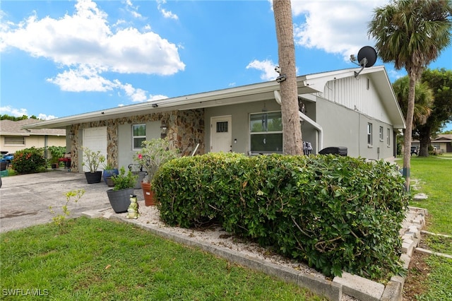 ranch-style home with a garage and a front lawn