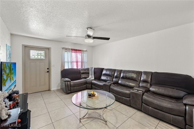 living room featuring ceiling fan, light tile patterned floors, and a textured ceiling