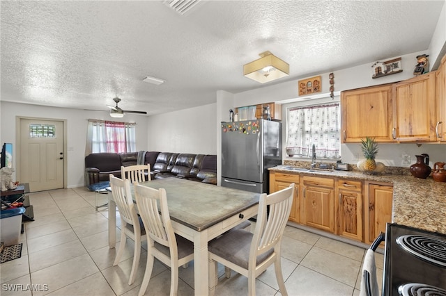 kitchen featuring stainless steel fridge, sink, stove, and a textured ceiling