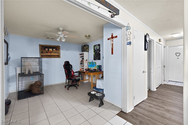 hall with a textured ceiling and light hardwood / wood-style flooring