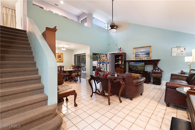 tiled living room featuring ceiling fan and high vaulted ceiling