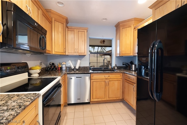 kitchen featuring dark stone counters, black appliances, sink, and light tile patterned floors