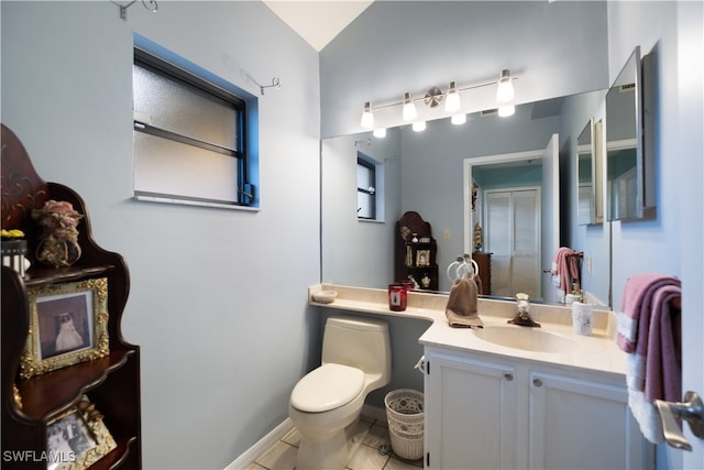 bathroom with tile patterned floors, lofted ceiling, vanity, and toilet