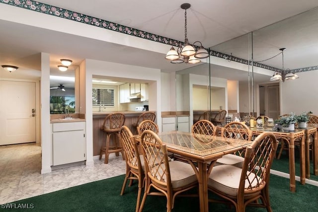 dining space featuring ceiling fan with notable chandelier and sink