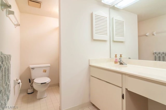 bathroom featuring tile patterned flooring, vanity, and toilet