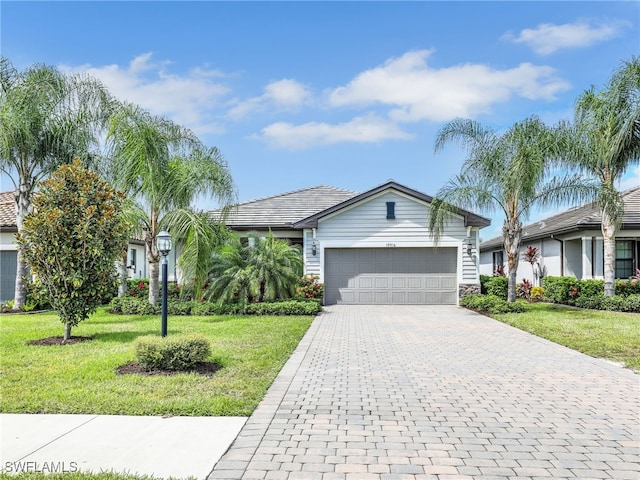 ranch-style home featuring a garage and a front lawn