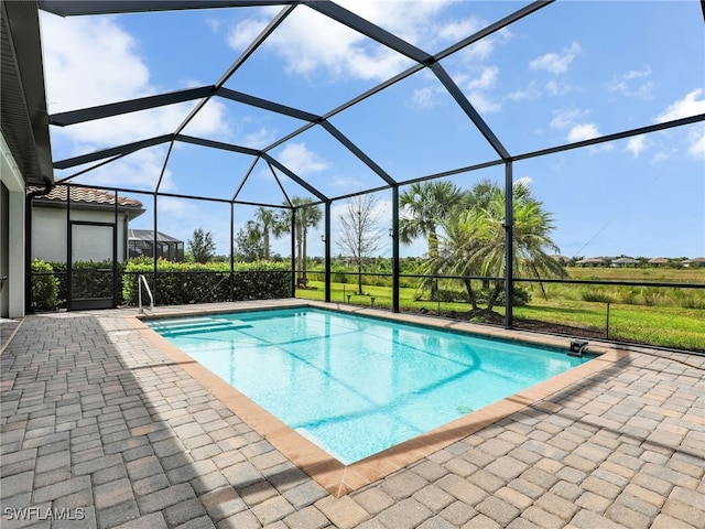 view of swimming pool featuring a patio area and a lanai