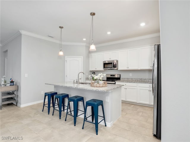 kitchen featuring a center island with sink, white cabinets, pendant lighting, and appliances with stainless steel finishes