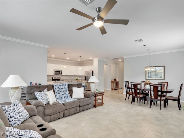 living room featuring ceiling fan with notable chandelier, ornamental molding, and sink