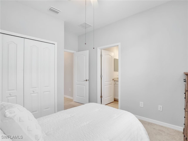 carpeted bedroom featuring ensuite bathroom, a closet, and ceiling fan