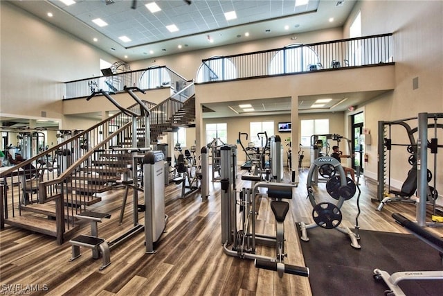 workout area with wood-type flooring and a high ceiling