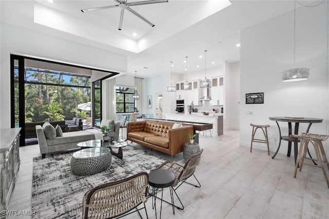 living room with ceiling fan and a raised ceiling