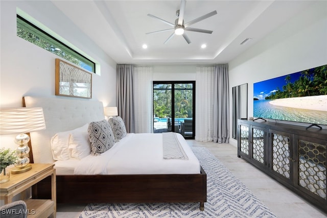 bedroom with access to outside, a tray ceiling, and ceiling fan