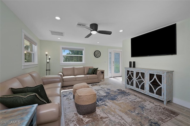 living room with ceiling fan and light hardwood / wood-style flooring