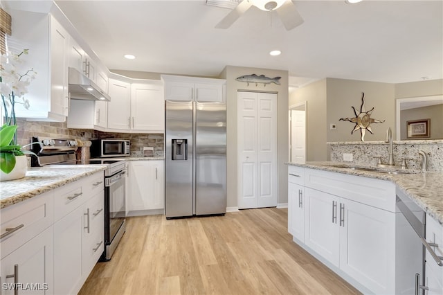 kitchen with appliances with stainless steel finishes, sink, light hardwood / wood-style floors, and white cabinets