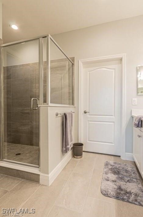 bathroom with vanity, a shower with shower door, and tile patterned flooring