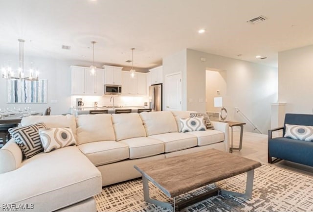 living room with an inviting chandelier and sink