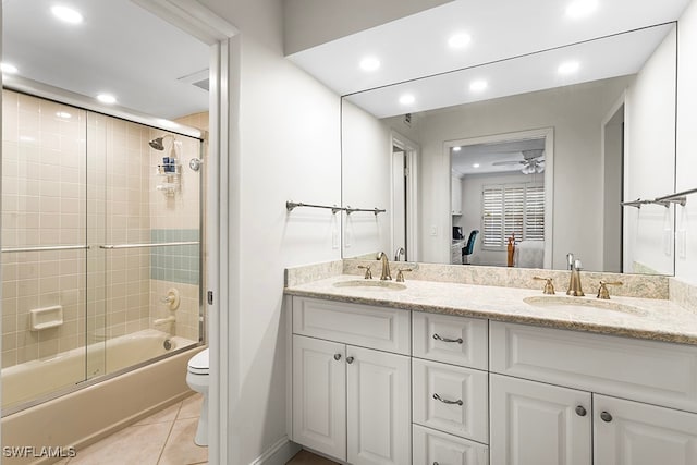 full bathroom with combined bath / shower with glass door, tile patterned floors, vanity, ceiling fan, and toilet