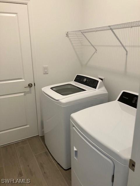 laundry area with washer and dryer and hardwood / wood-style floors