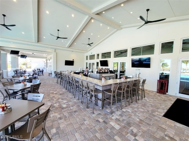 dining room featuring ceiling fan, beam ceiling, and high vaulted ceiling