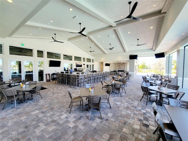 dining space with beam ceiling, ceiling fan, and high vaulted ceiling