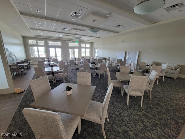 dining room featuring a drop ceiling and dark wood-type flooring