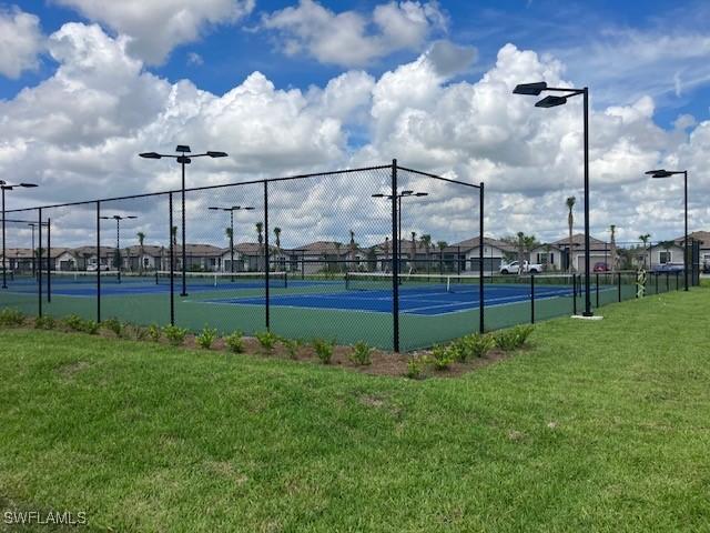 view of tennis court with a lawn