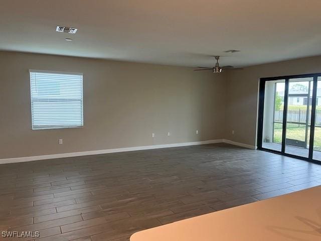 empty room featuring ceiling fan and dark wood-type flooring