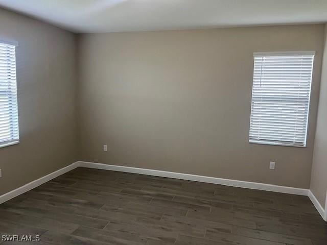 unfurnished room featuring a healthy amount of sunlight and dark hardwood / wood-style flooring