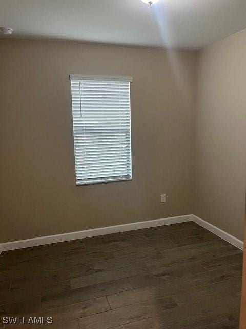 unfurnished room with dark hardwood / wood-style flooring