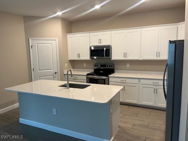 kitchen featuring white cabinetry, sink, an island with sink, and appliances with stainless steel finishes