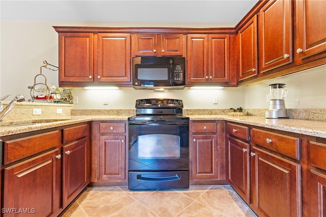 kitchen featuring light stone counters, light tile patterned flooring, black appliances, and sink