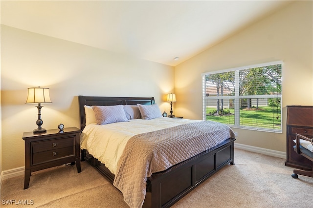 bedroom with lofted ceiling and light colored carpet