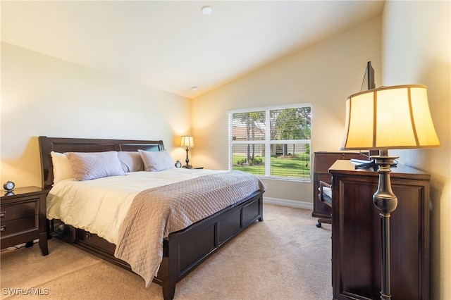 bedroom with lofted ceiling and light carpet