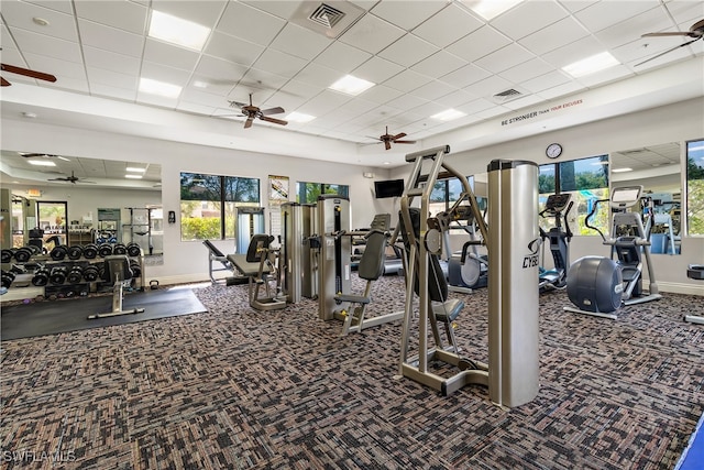 exercise room with a paneled ceiling and carpet