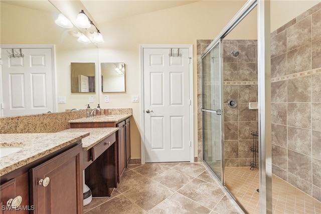 bathroom featuring vanity, a shower with shower door, and vaulted ceiling