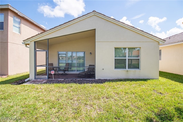 rear view of house with a yard and a patio