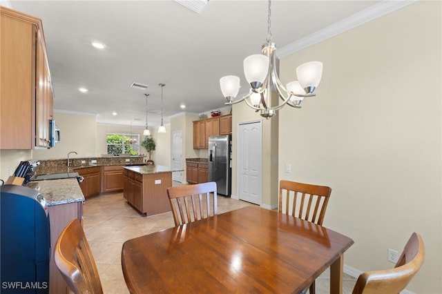 dining space featuring light tile patterned flooring, ornamental molding, an inviting chandelier, and sink