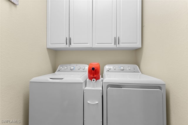 washroom featuring cabinets and independent washer and dryer