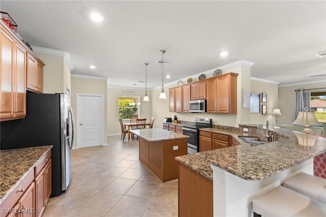 kitchen featuring a breakfast bar area, stainless steel appliances, a healthy amount of sunlight, and a center island