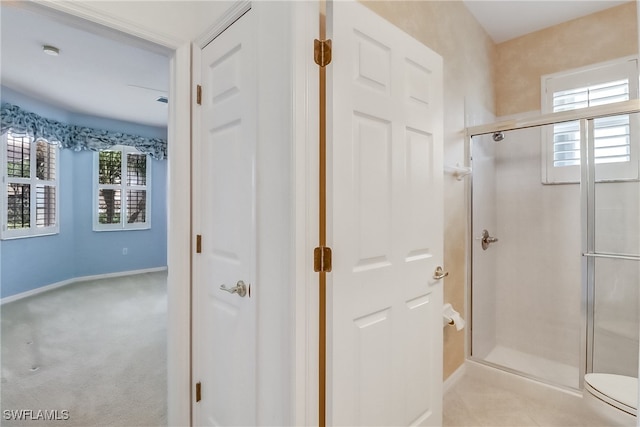 bathroom featuring walk in shower and toilet