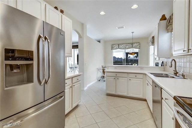 kitchen featuring stainless steel appliances, sink, tasteful backsplash, and white cabinetry