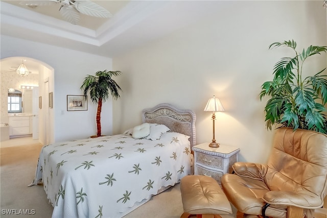 carpeted bedroom with ensuite bath and ceiling fan