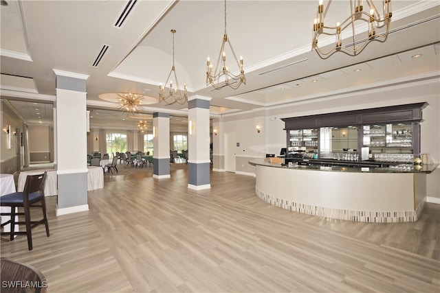 reception featuring decorative columns and an inviting chandelier