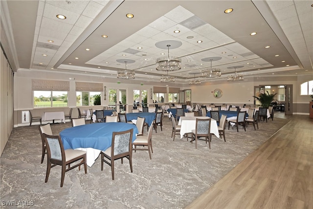 dining room with a notable chandelier, a tray ceiling, and hardwood / wood-style floors